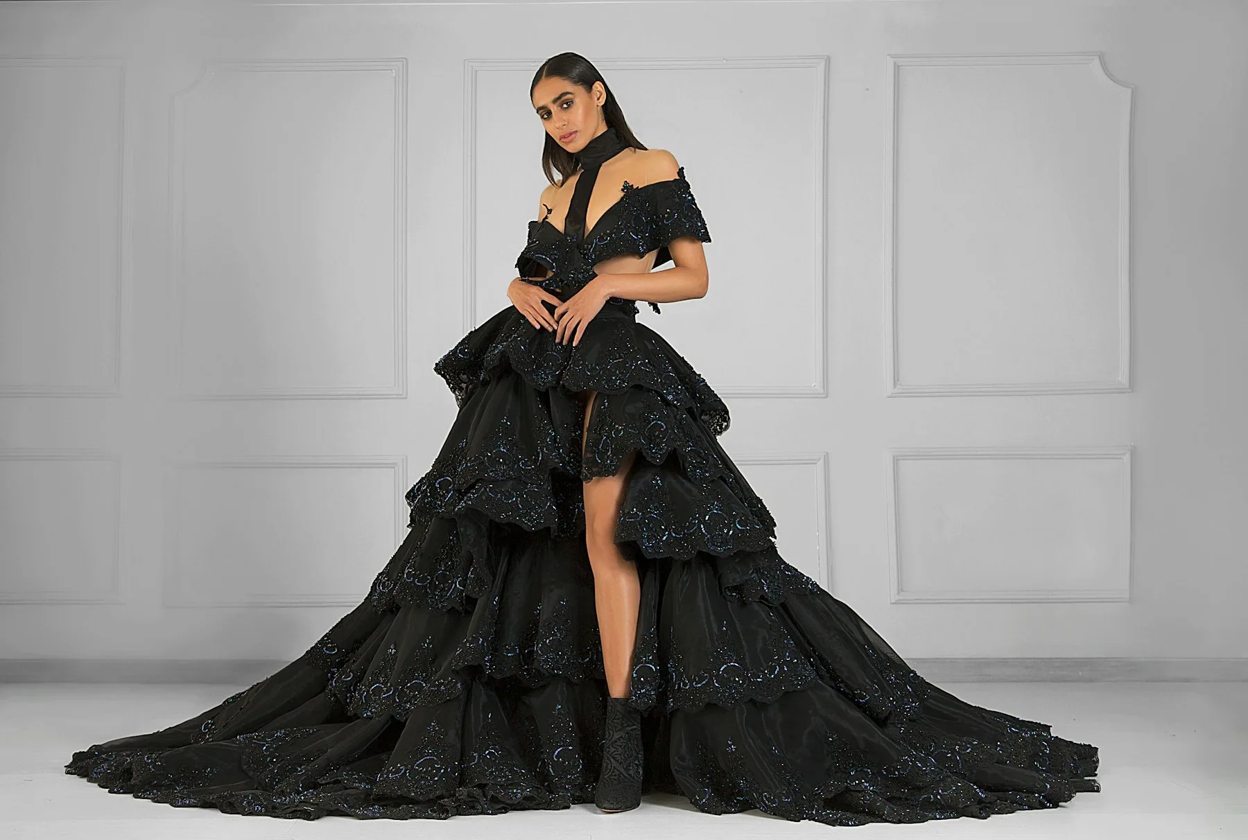 A model in a dramatic tiered black gown
