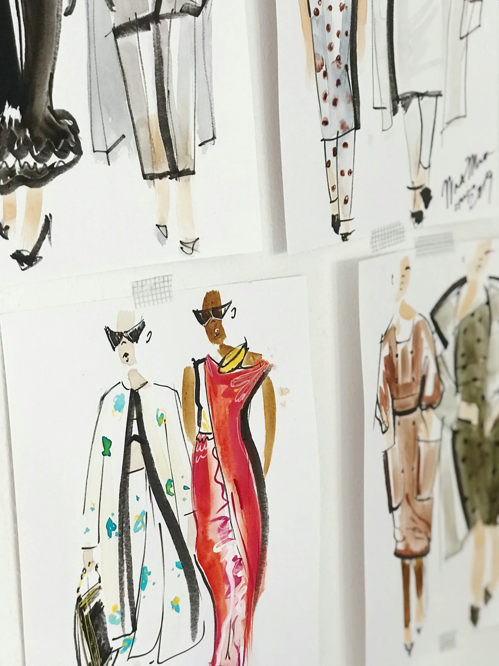 Fashion illustration sketches pinned to a studio wall