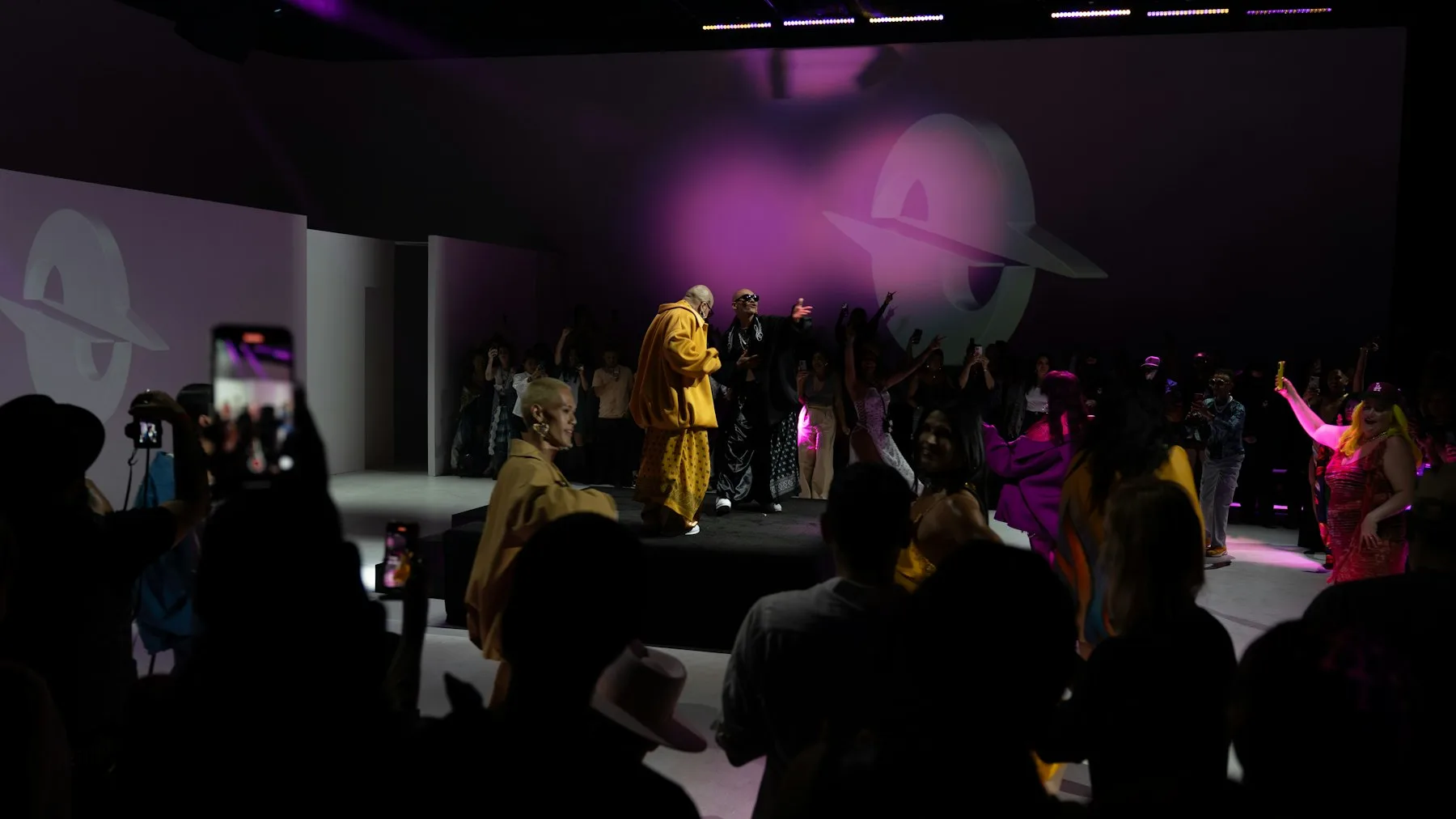 A performer on a lit stage before a crowd